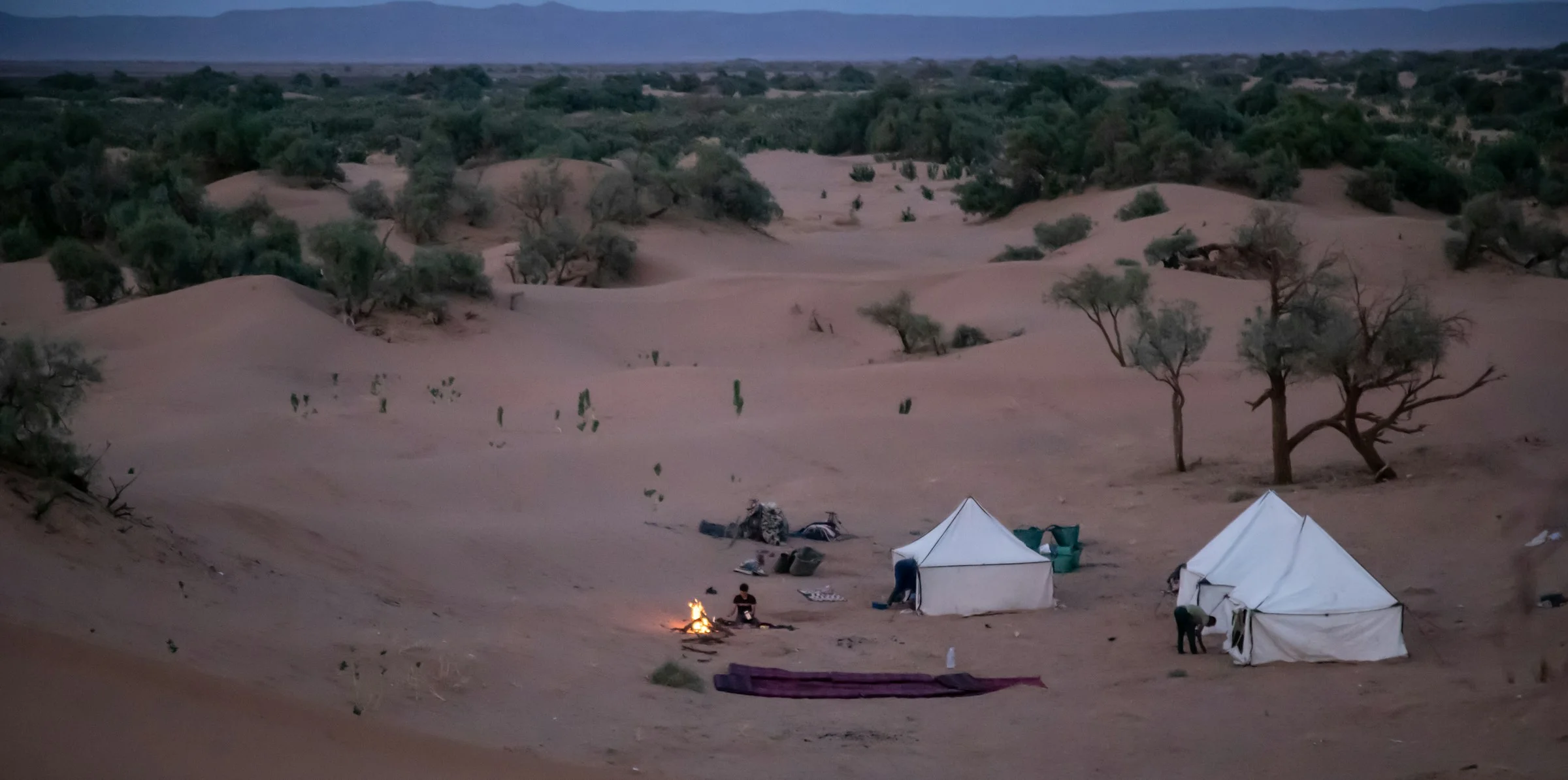 Desert dunes at dusk — remote luxury camp under open sky